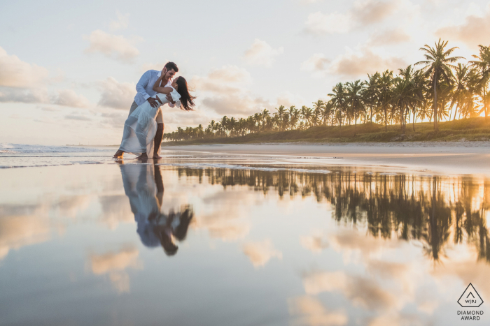 Marechal Deodoro couple pre-wed portrait in front of the sea with water reflections at sunset with some gentle wind