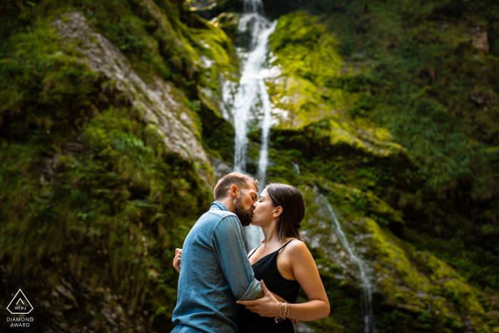 Friuli Venezia Giulia Fine Art Pré-casamento Retrato perto de Uma pequena cachoeira cercada por montanhas verdes é um cenário perfeito para este beijo apaixonado