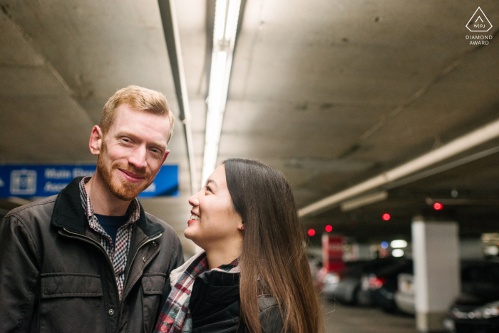 Ottawa, Ontário Foto de noivado artístico de um casal posando sob as luzes do estacionamento para uma foto de noivado ligeiramente diferente