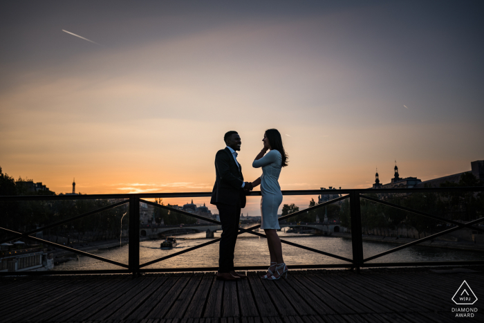 Sessão de caminhada no Paris Montmartre Fine Art Engagement na ponte sobre a água ao pôr do sol