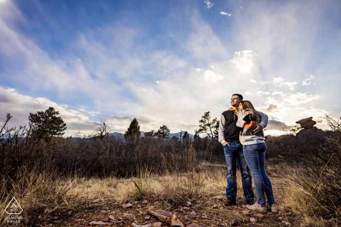 Sesión de compromiso de bellas artes del Jardín de los Dioses en Colorado Springs creada mientras la pareja disfruta de la puesta de sol