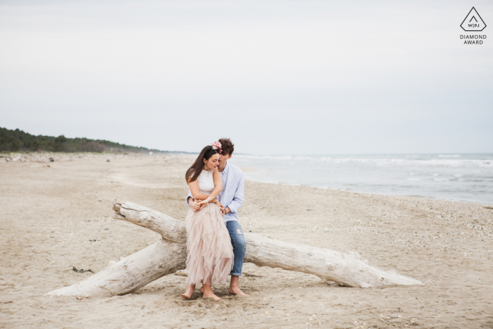 e-session portrait Ravenna Wild Beach - câlin de couple sur une bûche livrée par la mer