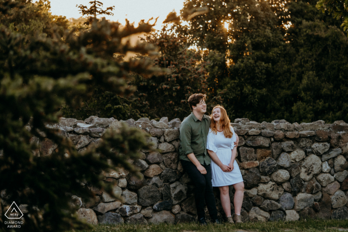 Halsweh Quarry Park Christchurch Portrait E-Session - ein Paar entspannt sich an einer Steinmauer