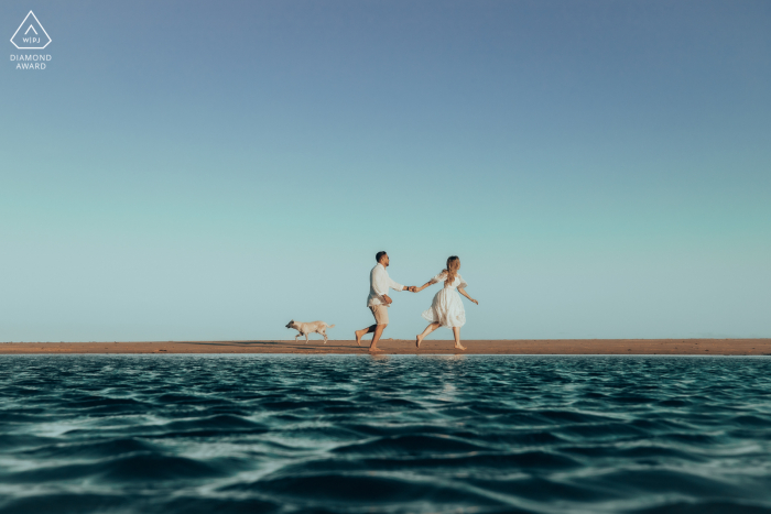 Maceió environmental engagement e-session of couple running, water, and a puppy