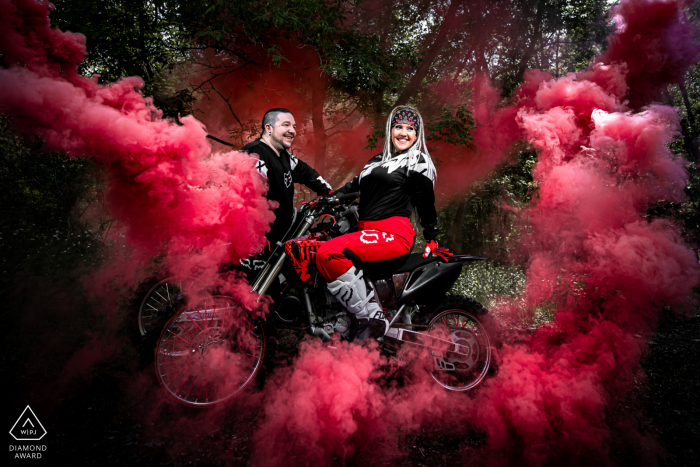 Minneapolis, MN portrait e-session avec l'aventure Couple sur leurs motos tout-terrain avec des bombes fumigènes derrière eux