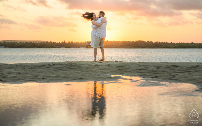 Maceió, Alagoas E-Session zum Umweltengagement mit einem lächelnden und tanzenden Mann und einer Frau am Strand