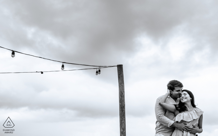 Maceió, Alagoas on-location portrait e-shoot created as a man hugs his bride-to-be on a rooftop