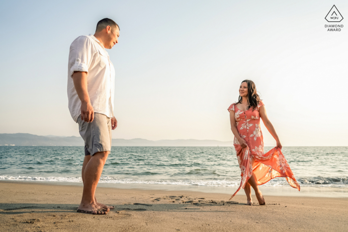 Sessione di ritratti pre-matrimonio True Love al Marriott Resort Puerto Vallarta in Messico che illustra una coppia che fa una passeggiata spensierata sulla sabbia della spiaggia