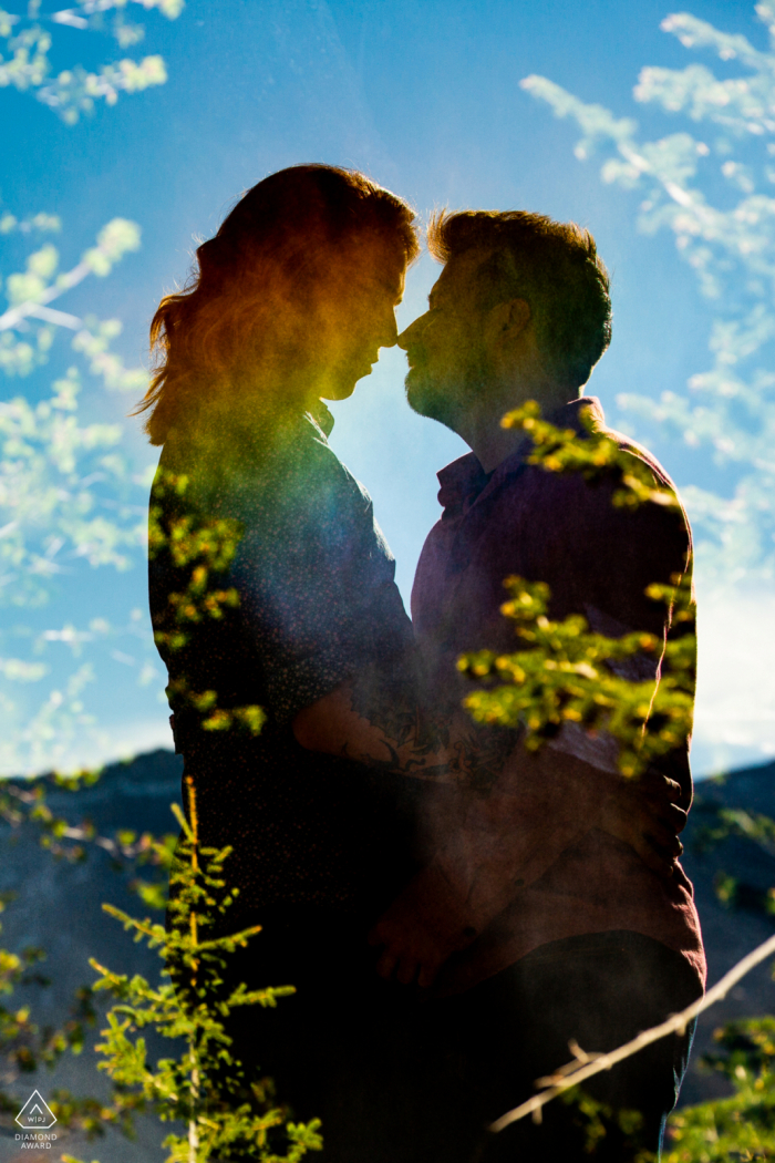 True Love Pre-Wedding Portrait Session in Telluride, bei der ein Paar in einer Doppelbelichtung mit einem Regenbogen an einem Wasserfall festgehalten wird