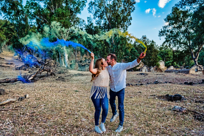 Sessione fotografica di fidanzamento di Jaén True Love al Pantano de El Jándula che mostra una coppia che tiene in mano bombe fumogene colorate