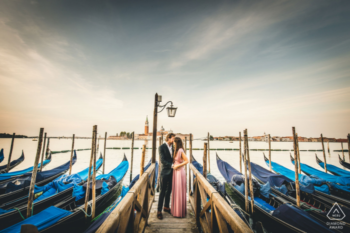 Sessione di ritratti di fidanzamento True Love a Venezia che mostra una coppia veneta in posa al molo circondata da barche