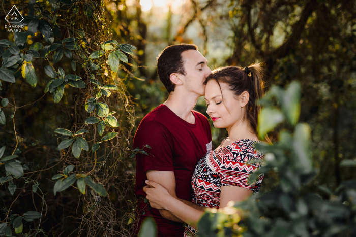 True Love Pre-Wedding Portrait Session in Montpellier capturing a couple kissing in the green lush forest