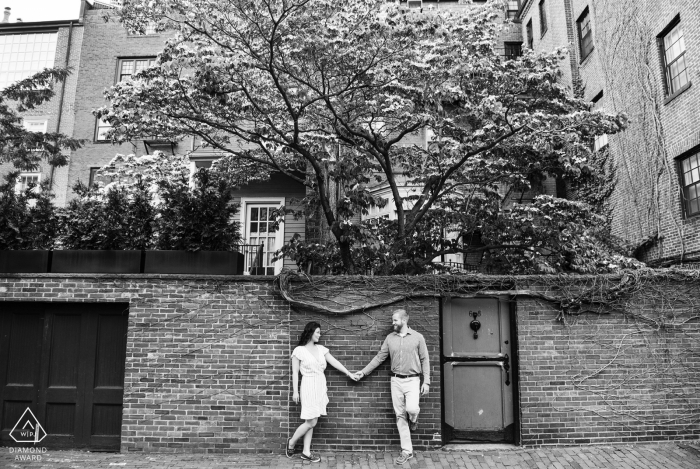 Beacon Hill, Boston couple e-shoot se tenant la main et se regardant contre le mur de briques