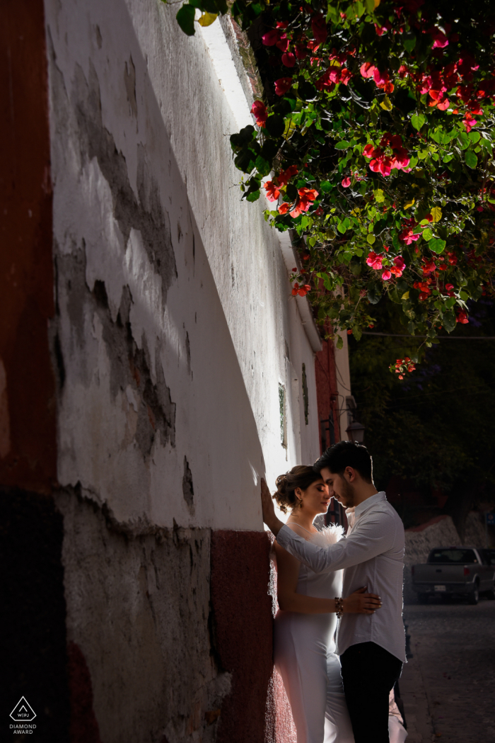 E-Session für Paare in der Calle del Chorro in San Miguel de Allende mit einem externen Blitz. Das Licht wurde absichtlich verwendet, um auch die Bougainvillea zu beleuchten und dem Foto einen dramatischen Effekt zu verleihen