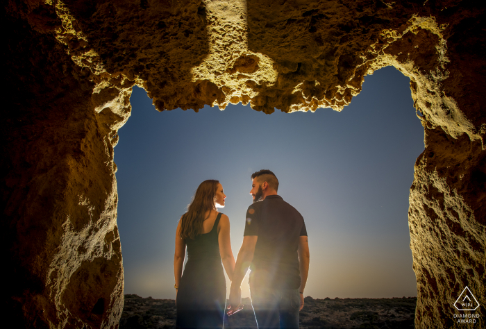 Murcia couple e-session in Aguilas framed by rocks at sunset