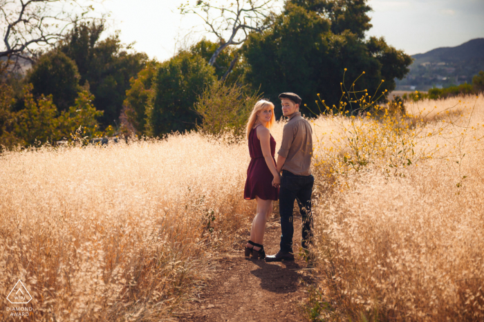 Satwiwa Trail, Newbury Park e-shoot de pareja mientras camina, la pareja se detiene y mira hacia atrás a la cámara