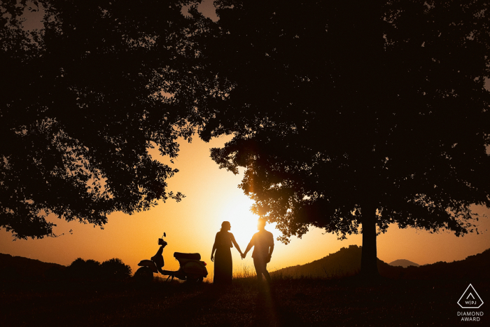 Alvito couple posturing for an engagement image at sunset with a moped in Frosinone