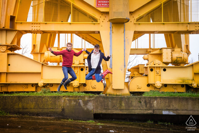 Nantes bride and groom to be, jumping for an engagement image near the industrial equipment