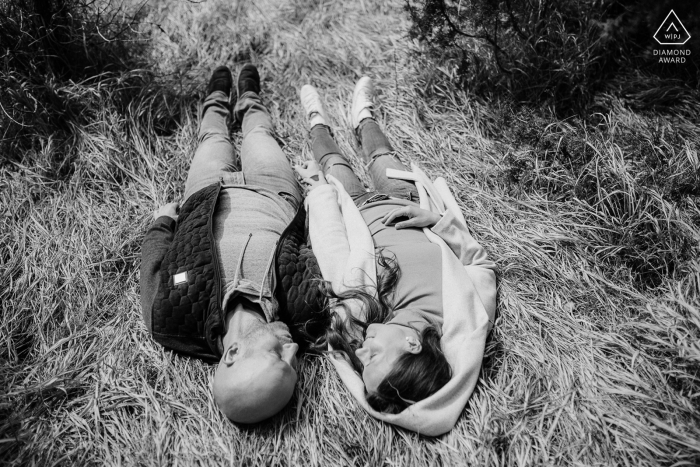 Slovenia bride and groom to be, lying in the grass for a BW engagement image at Banska Bystrica