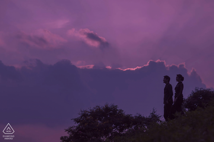 La futura sposa e lo sposo di Shenzhen, modellano per una foto pre-matrimonio in Cina contro un cielo viola con nuvole