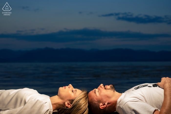 Genève outside environmental prewedding photoshoot of a couple lying in front of the lake