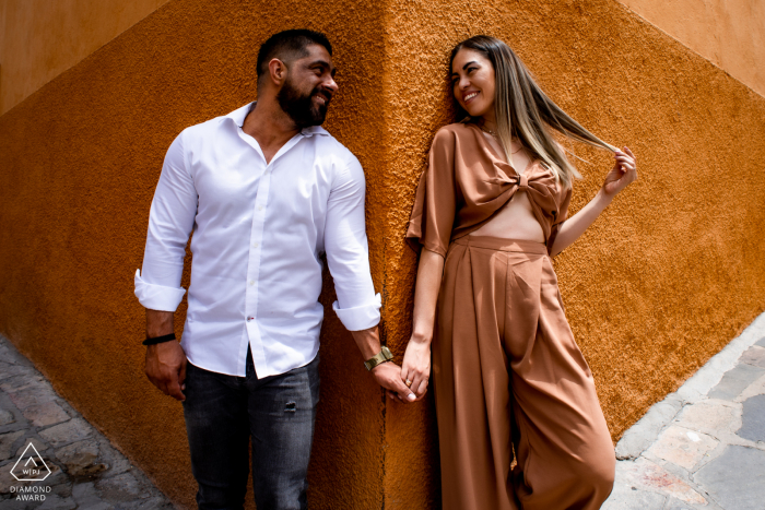 Calle Recreo, San Miguel de Allende sessão de imagens ambientais pré-casamento com o casal em um canto e trabalhando com perspectiva para fazer esta fotografia simétrica e agradável aos olhos