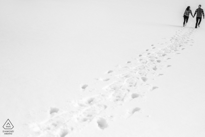 Squaw Valley Lake Tahoe fuera de pareja ambiental sesión de fotos preboda mostrando huellas en la nieve fresca del invierno