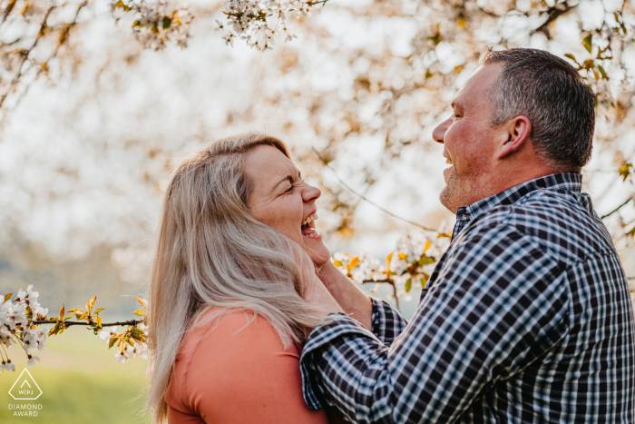 Outdoor Oberhausen, Germany couple engagement photography portrait under blooming trees with fun