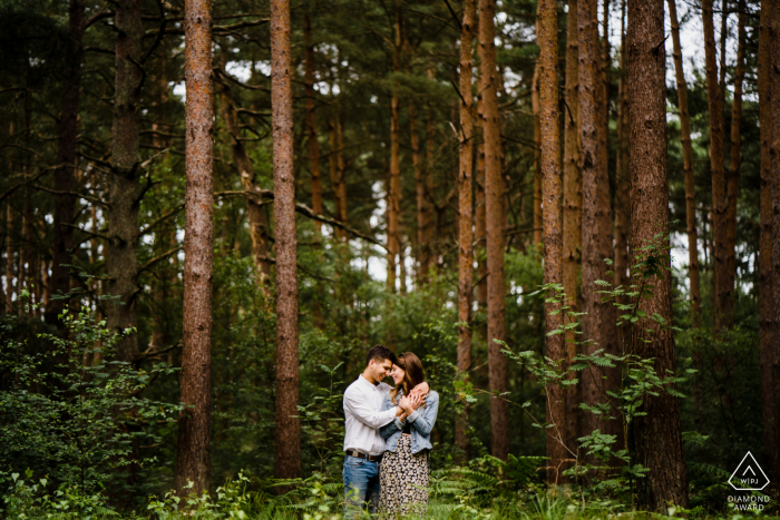 Heath, West Sussex outside environmental couple prewedding photoshoot below the towering tree forest