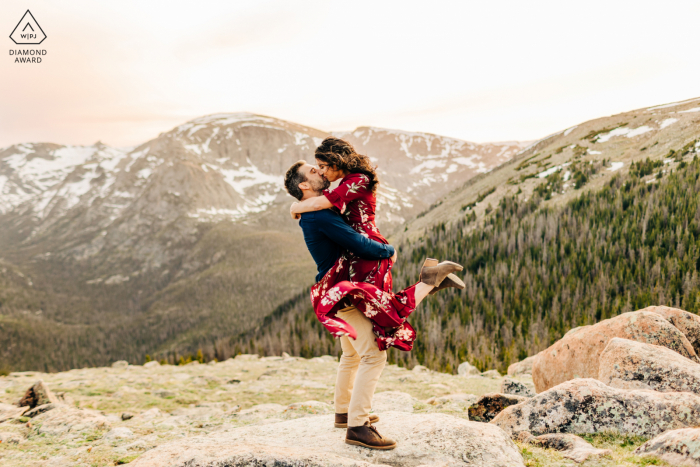 On location Rocky Mountain National Park couple engagement portrait shoot with a guy lifting girl