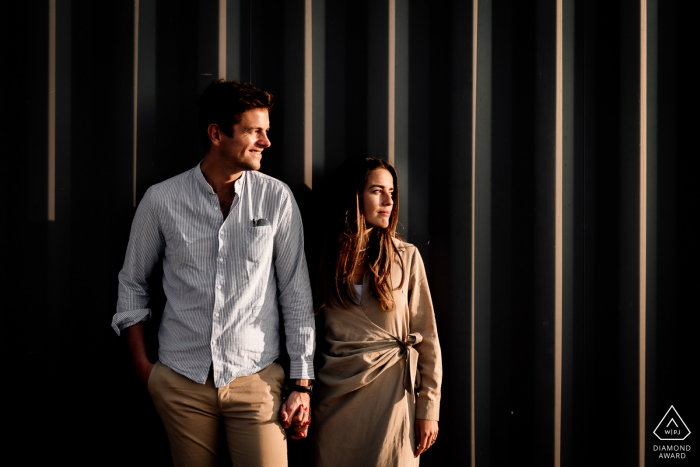 Montpellier pre-wedding portrait-session with sunlight and vert lines on the wall behind them