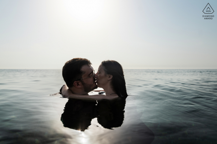 Séance d'images de fiançailles d'un couple avant le mariage sur la plage de Perpignan en France avec des baisers dans la mer