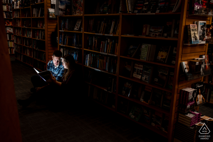 Séance photo avant le mariage à Minneapolis dans une bibliothèque pendant que le couple lit ensemble