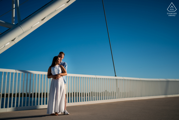 Sesión de imágenes de compromiso previa a la boda en Perth, WA con la pareja de pie juntos en el puente del cable