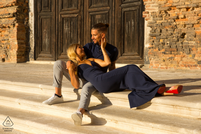 Venice romantic engagement image of a couple sitting on the stairs at Chiesa di San Lorenzo