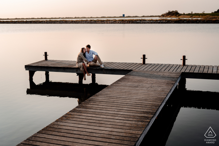 Eine Sitzung vor der Hochzeit in Montpellier, Frankreich, die den Spaß hervorhebt, den sie gemeinsam auf dem Steg an einem ruhigen und stillen See haben