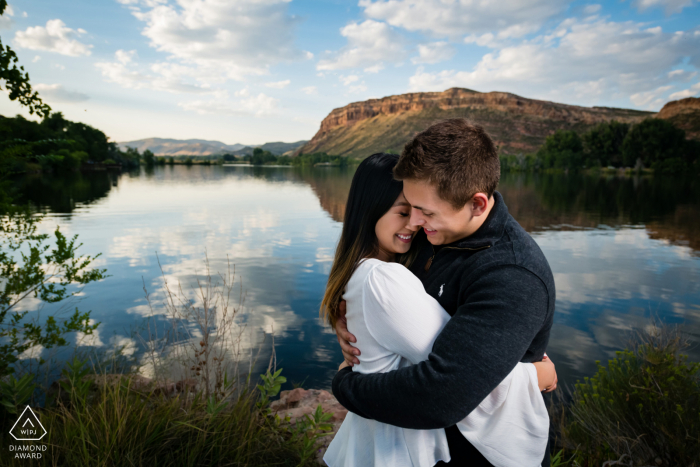 Uma sessão de noivado antes do casamento em Bellvue, Colorado, com um casal que sabe como se divertir enquanto se abraçam em frente a um lago