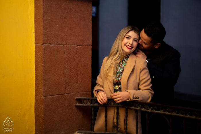 A sweet and serene Calle Correo engagement session for an image taken under a fountain painted yellow for the warm skin tones and a lovely color scheme