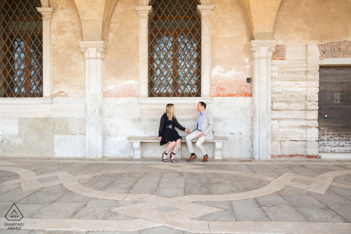 Une belle photo de fiançailles de Venise au Palazzo Ducale au Palais des Doges avec le couple italien assis sur un banc