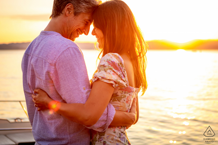 Ein italienischer Hochzeits-, Elopement- und Verlobungsfotograf hat dieses künstlerische Sonnenuntergangsporträt dieses Gardasee-Paares bei einem Spaziergang am Seeufer erstellt