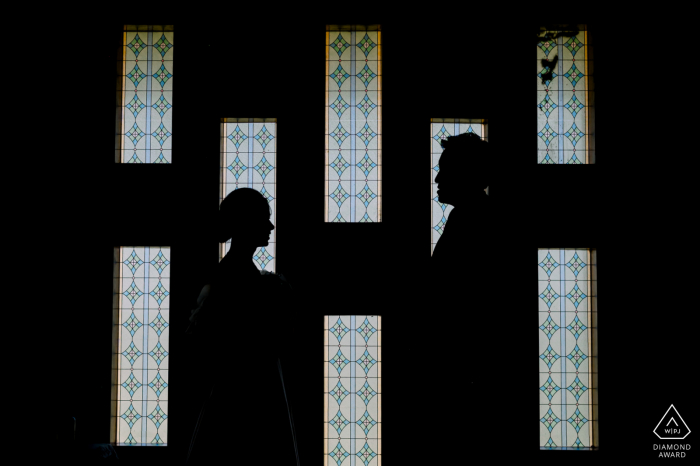 Ein thailändischer Hochzeits-, Elopement- und Verlobungsfotograf hat dieses kreative Silhouettenporträt dieses Paares aus Bangkok erstellt, das in den Fenstern posiert