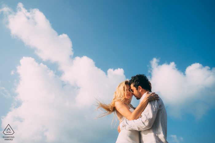 Um fotógrafo de casamento, fuga e noivado da Tailândia criou este retrato artístico e minimalista deste casal Koh Samui abraçado ao vento e nuvens em Mimosa