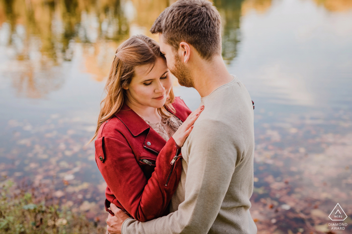 Un photographe allemand de mariage, de fugue et de fiançailles a créé ce portrait créatif et calme de ce couple de Dortmund debout sur la rive d'un lac en automne