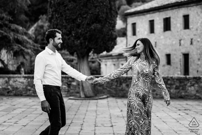 Um fotógrafo de casamento, fuga e noivado de Trieste criou este retrato criativo em preto e branco deste casal de Pádua no Arquà Petrarca caminhando juntos em um calçadão de tijolos