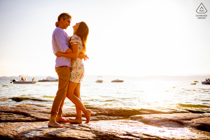 Estilo de vida do Lago Garda casais fotografia de retrato em Simione, Lombardia, Itália na água e beijando pelo pôr do sol