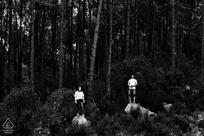 Sintra couples wooded lifestyle photography in Lisbon, Portugal as the pair stand in a rock with big trees at their backs 