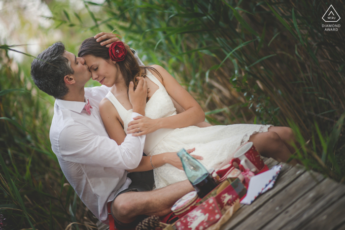 Dragoman post propuesta de sesión de retratos con un fotógrafo de compromiso de Bulgaria de una pareja de Sofía celebrando la Navidad en agosto con un picnic en un puente peatonal de madera