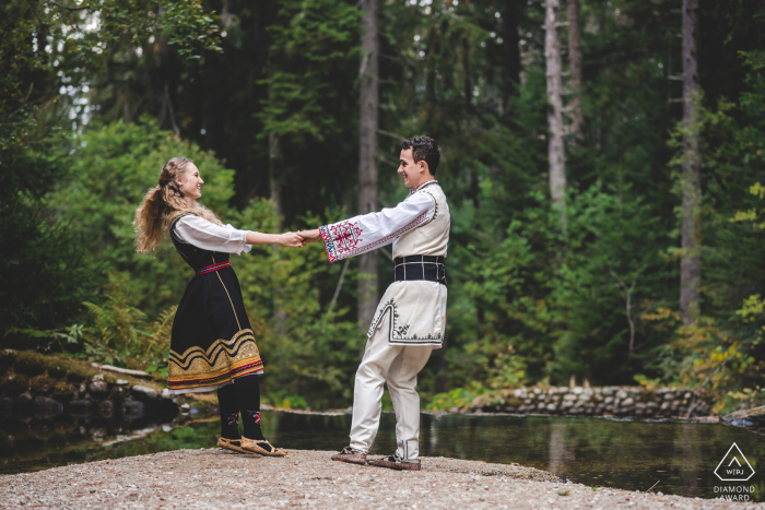 Borovets post-proposition séance de portrait avec un photographe de fiançailles à Sofia d'un couple bulgare dansant ensemble en vêtements traditionnels Borovets post-proposition séance de portrait avec un photographe de fiançailles à Sofia d'un couple bulgare dansant ensemble en vêtements traditionnels