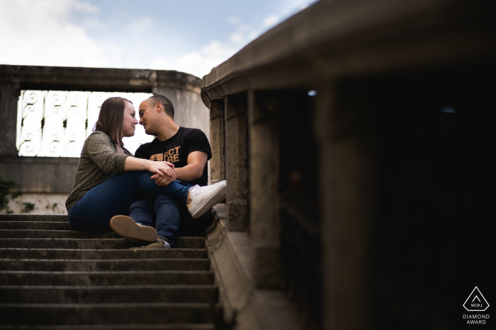 Nérac poste des photos de portrait de proposition d'un couple heureux du Lot-et-Garonne assis avec des jambes verrouillées en haut d'un escalier en béton