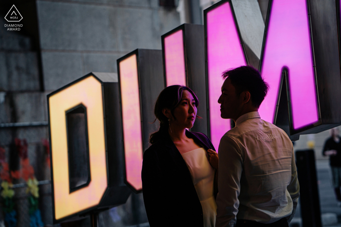 DUMBO sign post propuesta fotos de retrato de una feliz pareja de Nueva York al atardecer con luz en el borde y una silueta